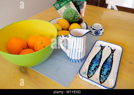 Plaque en céramique traditionnel portugais bleu avec deux poissons à rayures peintes à la main, verseuse et bols de fruits sur table dans Porto Portugal Europe KATHY DEWITT Banque D'Images