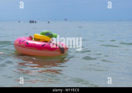 Un 3-année-vieux garçon nage dans la mer dans un gilet et bague en caoutchouc. Personnes non visible tôt le matin Banque D'Images