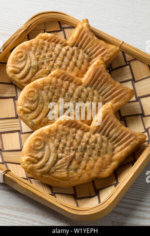 Fresh baked Taiyaki, gâteau en forme de poissons japonais rempli de pâte de haricots rouges dans un panier Banque D'Images