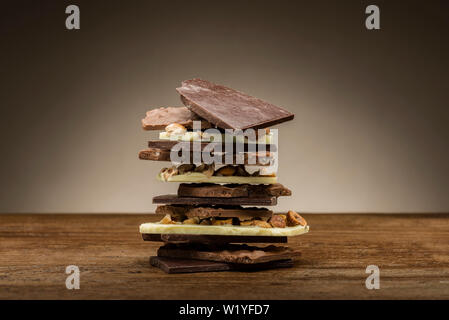 Pile de pièces en chocolat mixtes, on wooden table Banque D'Images