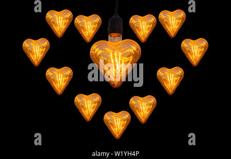 Ampoules Orange isolés à forme de coeur sur un fond noir avec le chemin de détourage. Banque D'Images