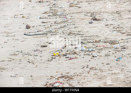 Bouteilles en verre, des déchets et des sacs en plastique sur la plage. Banque D'Images