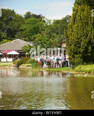 Les foules à Burnby Hall Gardens, à commencer une visite guidée des jardins d'eau qui composent la collection nationale de nénuphars. Banque D'Images