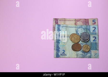 Pile de faible valeur de l'argent brésilien sur fond rose avec copie espace pour le texte. L'argent d'économie au Brésil est difficile pour la génération du nouveau millénaire. La manière de procéder ? Banque D'Images