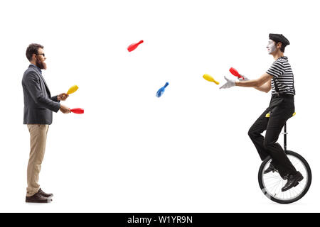 De toute la longueur d'un mime sur un monocycle jonglage avec un homme isolé sur fond blanc Banque D'Images