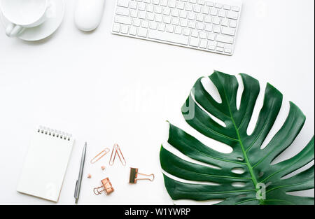 Vue de dessus de bureau avec table et feuilles monstera accessoires maquette sur fond blanc.télévision jeter design.copy space Banque D'Images