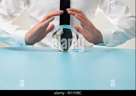 Vue de face d'un homme tenant les mains de protection sur une sphère de cristal dans une image conceptuelle. Banque D'Images