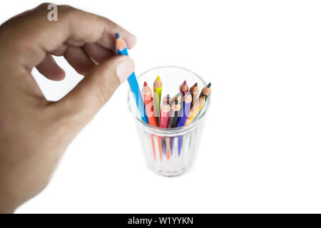 Les hommes prennent un crayon bleu de mug en verre transparent isolé sur blanc. Banque D'Images
