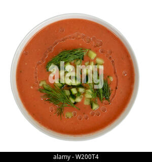 Gaspacho délicieux saupoudré d'aneth et concombre haché dans un bol blanc, vue du dessus, isolé sur fond blanc. Banque D'Images