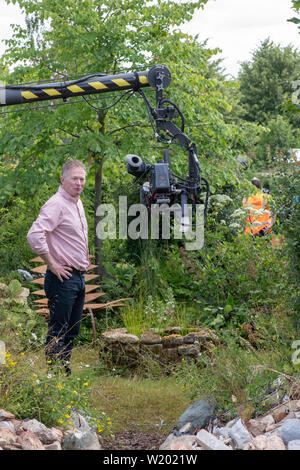 Toby Buckland faisant un morceau à l'appareil photo dans le calme contre le chaos voir jardin de RHS Hampton Court Flower Show 2019. Hampton Court Palace, Surrey, UK Banque D'Images