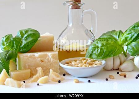 Ingrédients pour faire la sauce pesto traditionnel italien : feuilles de basilic, parmesan, huile d'olive, noix de pin et l'ail. Vue de dessus avec l'exemplaire de l'espace. Banque D'Images