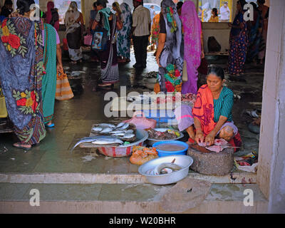 Gujarat, Inde - Novembre 3, 2016 : une femme non identifiée de vendre du poisson fraîchement débarqué dans le marché à quai au port de Vanakbara sur l'île de Diu Banque D'Images