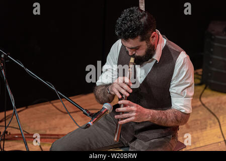 Bon avec une épaisseur de l'homme à la barbe noire, le musicien joue un turc typique, la flûte ney, sur scène Banque D'Images