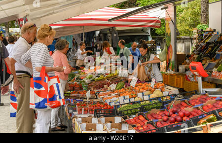 Lezzeno, Lac de Côme, Italie - Juin 2019 : Les gens d'acheter les fruits et légumes d'un décrochage dans le marché de producteurs à Lenno, sur le lac de Côme. Banque D'Images