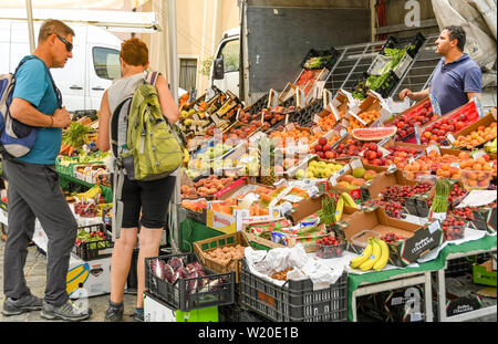 Lezzeno, Lac de Côme, Italie - Juin 2019 : Les gens d'acheter les fruits et légumes à partir d'un stand dans le marché de producteurs à Lenno, sur le lac de Côme. Banque D'Images