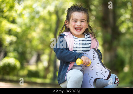 Cute girl enjoying sur aire de jeux dans le parc en été . Banque D'Images