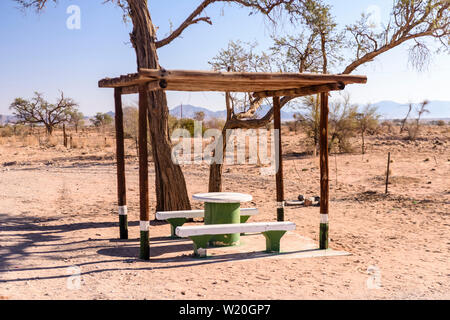 Table de pique-nique et des bancs en béton avec un auvent pour l'ombre, généralement placés tous les 10-20km le long des routes en Namibie Banque D'Images