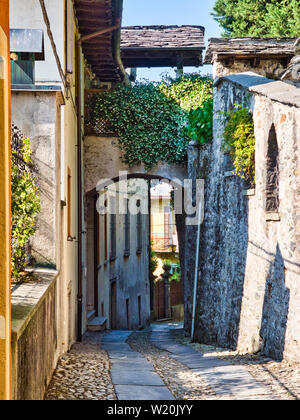 La rue déserte avec via et de murs en pierre à l'île de San Giulio sur le lac d'Orta Italie pendant un après-midi d'été Banque D'Images