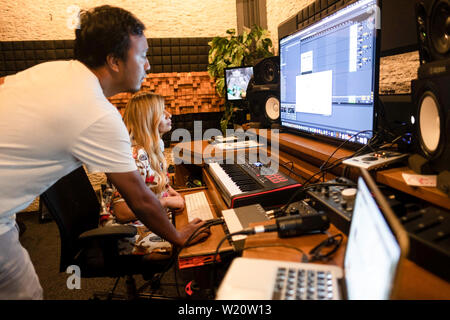 Ingénieur du son avec une femme blonde musicien dans un studio de musique moderne Banque D'Images