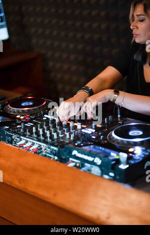 Party Time avec blonde female DJ dans un night club de musique. Le mélange de musique électro et de l'utilisation des écouteurs. Banque D'Images