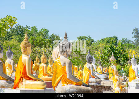 Derrière la statue de Bouddha recouvert de tissu jaune fond de ciel au Wat Phai Rong Wua , Suphan Buri, en Thaïlande. Banque D'Images