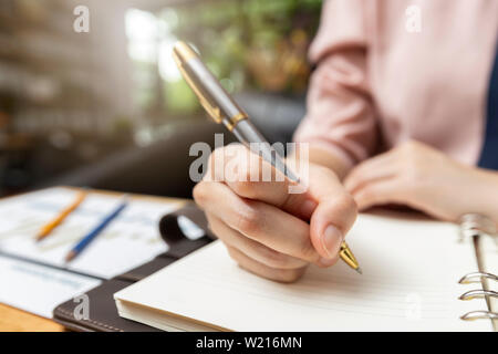 Portrait ou en indiquant sur papier du rapport. La stratégie de l'entreprise concept. Close up shot businesswoman writing notes dans l'ordinateur portable Banque D'Images