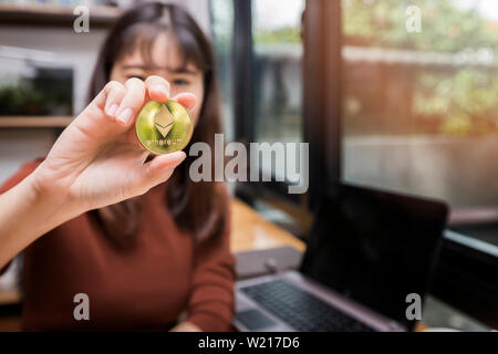 Golden Ethereum coin (cryptocurrency) dans la main de femme d'affaires. Nouveau concept de l'argent virtuel Banque D'Images