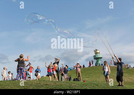 Un homme divertit les enfants avec des bulles de savon géantes au quatrième jour de l'indépendance d'été Seafair Célébration à gas works Park le 4 juillet 2019 à Seattle, Washington. Banque D'Images