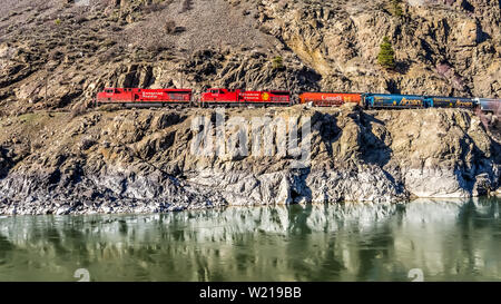 Les trains de marchandises à la suite de la Thompson et du Fraser le long des falaises et des tunnels dans le canyon du fleuve Fraser et Thompson, C.-B., Canada Banque D'Images