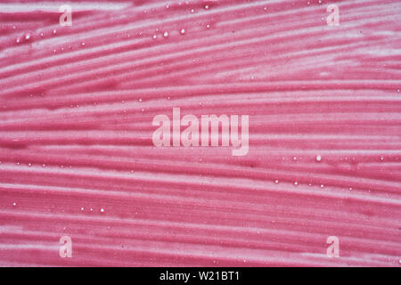 Traits rose doucement et la texture de la peinture acrylique ou brillant à lèvres isolé sur fond blanc Banque D'Images