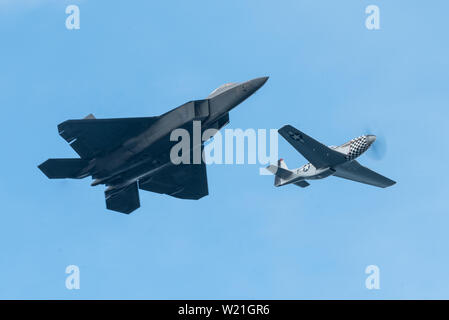 U.S. Air Force Maj Paul Lopez, commandant de l'équipe Démo F-22 vole à côté du patrimoine de l'US Air Force Flight Fondation P-51 pilote, le Lieutenant-colonel Charles Hainline, pendant la fête de la cerise à Traverse City (Michigan), le 29 juin 2019. L'Armée de l'air Vol du patrimoine Fondation célèbre histoire d'alimentation de l'air américaine et sert de mémorial vivant de ceux qui ont servi dans l'US Air Force en fournissant des démonstrations en vol du patrimoine annuelle 40-60 autour du monde. (U.S. Photo de l'Armée de l'air par Slt Samuel Eckholm) Banque D'Images