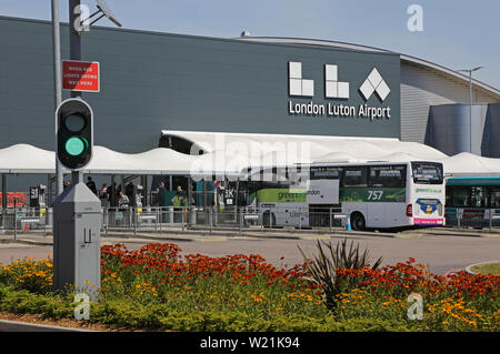 L'aéroport de Luton, Londres. Aire de débarquement des passagers et de la station de bus en face du bâtiment principal du terminal - avec nouveau logo (été 2019) Banque D'Images