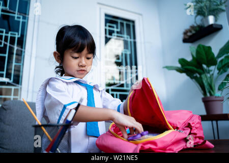 Les jeunes élèves de maternelle indépendant prépare ses propres affaires avant d'aller à l'école le matin Banque D'Images