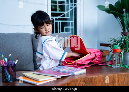 Les jeunes élèves de maternelle indépendant prépare ses propres affaires avant d'aller à l'école le matin Banque D'Images