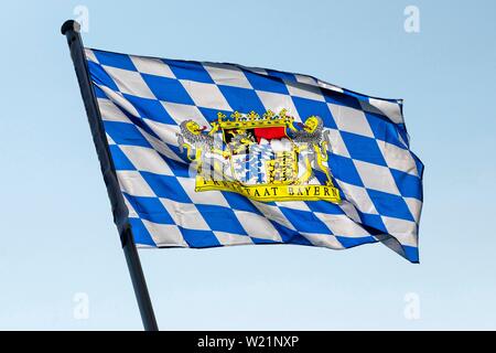 Un drapeau bleu-blanc avec les armoiries de l'Etat libre de Bavière dans le vent souffle dans Markt souabe, Bavière, Allemagne Banque D'Images