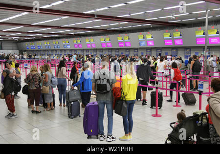 L'aéroport de Londres Luton, Royaume-Uni, salle d'enregistrement. Les passagers de Wizz Air la queue pour avoir de l'archipel. Le Luton salle d'enregistrement a 62 pupitres dans une seule ligne. Banque D'Images