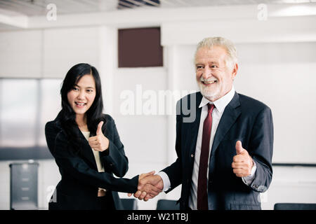 Business people shaking hands and smiling leur accord à signer contrat et finir une séance Banque D'Images