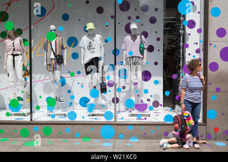 Une femme et enfant devant la fenêtre d'affichage de thème-Topshop sur Oxford Street, le 2 juillet 2019, à Londres, en Angleterre. Banque D'Images