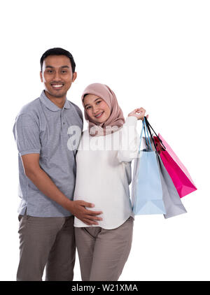 Femme Asiatique enceinte et mari transportant quelques sacs de shopping à fond isolé Banque D'Images