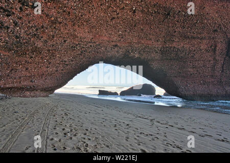 Red Rock formation avec arch sur la plage, plage Sidi Ifni, Maroc, Afrique Banque D'Images