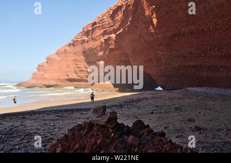 Red Rock formation avec arch sur la plage, plage Sidi Ifni, Maroc, Afrique Banque D'Images