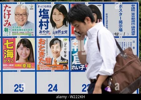 Tokyo, Japon. 05 juillet, 2019. Un homme passe devant une affiche érigée avec des affiches pour des candidats le 21 juillet l'élection à la Chambre haute. Les campagnes pour l'élection à la Chambre haute a officiellement vu le jour le Jeudi, 04 juillet, et aura lieu le 21 juillet. Credit : Rodrigo Reyes Marin/AFLO/Alamy Live News Banque D'Images