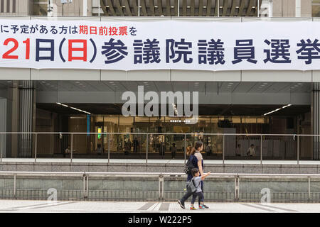 Tokyo, Japon. 05 juillet, 2019. Les gens passent devant une bannière pour Juillet 21 élection à la Chambre haute à l'extérieur de la ville de Tokyo. Les campagnes pour l'élection à la Chambre haute a officiellement vu le jour le Jeudi, 04 juillet, et aura lieu le 21 juillet. Credit : Rodrigo Reyes Marin/AFLO/Alamy Live News Banque D'Images