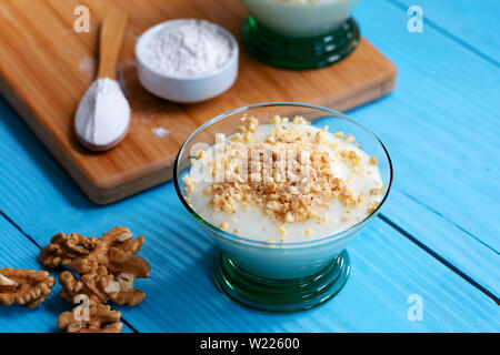 Crème anglaise faite maison avec le noyer, Turkish muhallebi sur fond de bois Banque D'Images