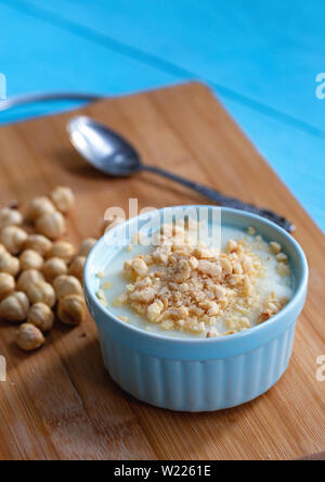 Crème anglaise faite maison avec le noyer, Turkish muhallebi sur fond de bois Banque D'Images