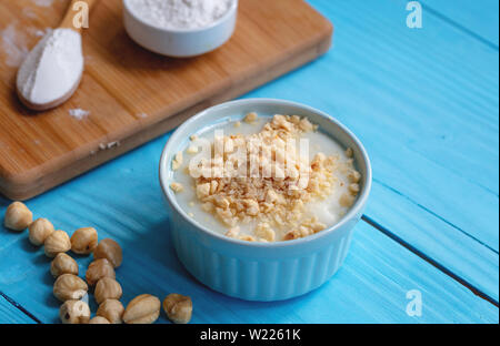 Crème anglaise faite maison avec le noyer, Turkish muhallebi sur fond de bois Banque D'Images