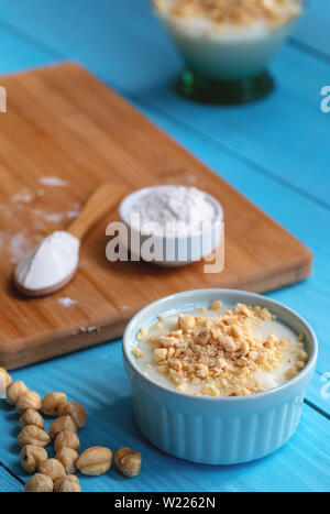 Crème anglaise faite maison avec le noyer, Turkish muhallebi sur fond de bois Banque D'Images