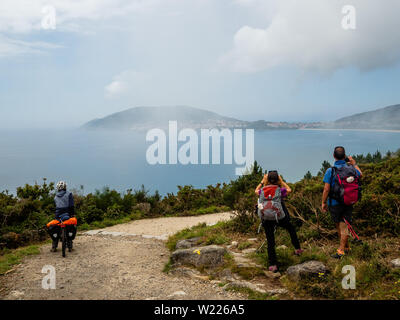 Les pèlerins sont vus à la prise de photos et pour la première fois le cap Finisterre. Le cap Finisterre est la destination de ces pèlerins qui, après avoir visité le tombeau de Saint James' est Santiago, continuent leur chemin le long du tracé pour eux par-dessus la Voie lactée jusqu'à ce qu'ils ne pouvaient faire plus. Finisterre a été examiné au cours de la période de l'Antiquité classique à la fin du monde connu. Finisterre, Fisterra ou en galicien, le dialecte de Galice, signifie "Land's End" en latin. Ensuite, pour le phare, il y a le marqueur de 0,0 kilomètres où l'Océan Atlantique peut être vu Banque D'Images