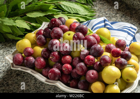 Produits frais bio prunes jaunes et rouges en céramique en aliments sains. Banque D'Images