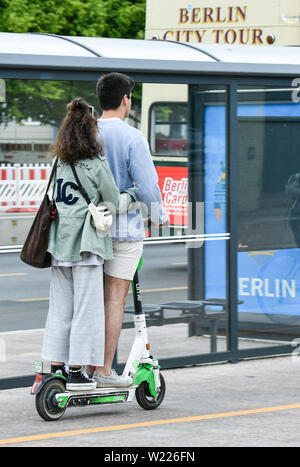 05 juillet 2019, Berlin : deux personnes conduisent ensemble en même temps sur une pédale électrique scooter. E-scooters peuvent être utilisés en Allemagne depuis la mi-juin. Photo : Jens Kalaene Zentralbild-/dpa/ZB Banque D'Images